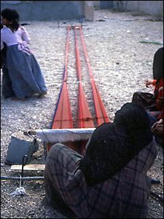 woman weaving on ground loom